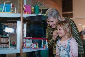 Une enfant et une personne aînée admirent une maquette produite dans le cadre de l'exposition