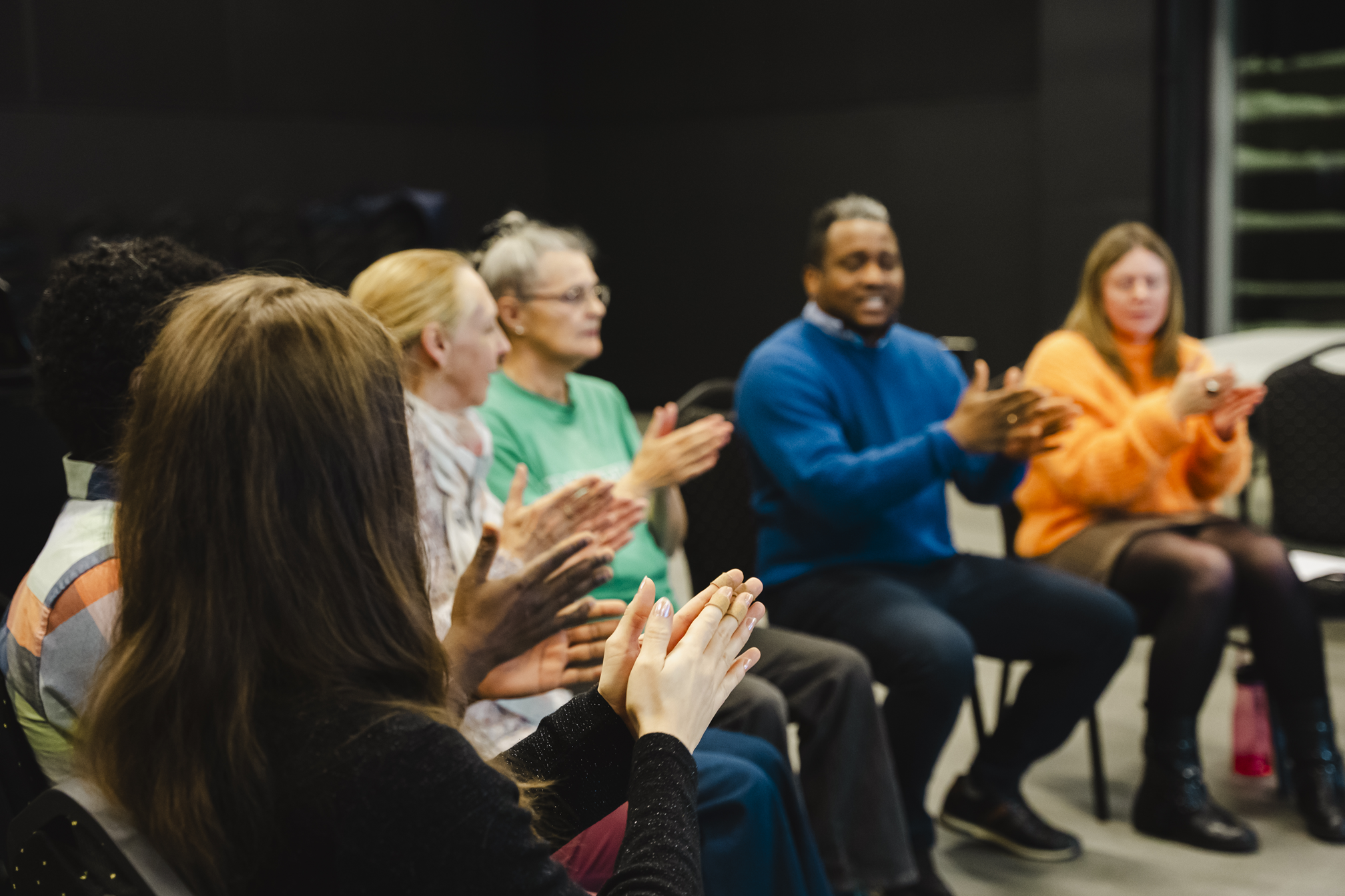 La 2e cohorte des ateliers de cocréation musicale Racines chantantes. Des gens d'âges et d'origines diverses assis en cercle tapent dans leurs mains.