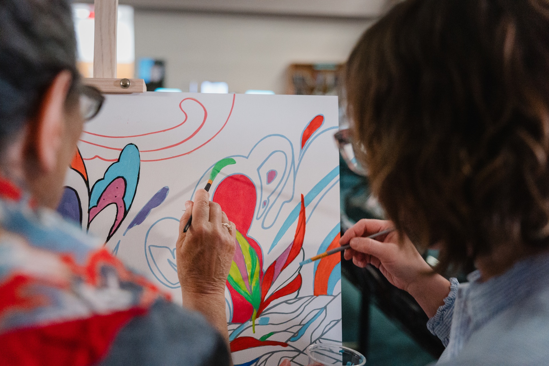 Deux personnes font de la peinture sur une toile